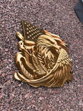 Wooden plaque with an eagle and American flag design on a gravel surface