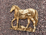 3D illusion double exposure of a horse with a mountain scene inner image, laser burned into wood.  Shown at an angle and laying on a gravel backdrop.
